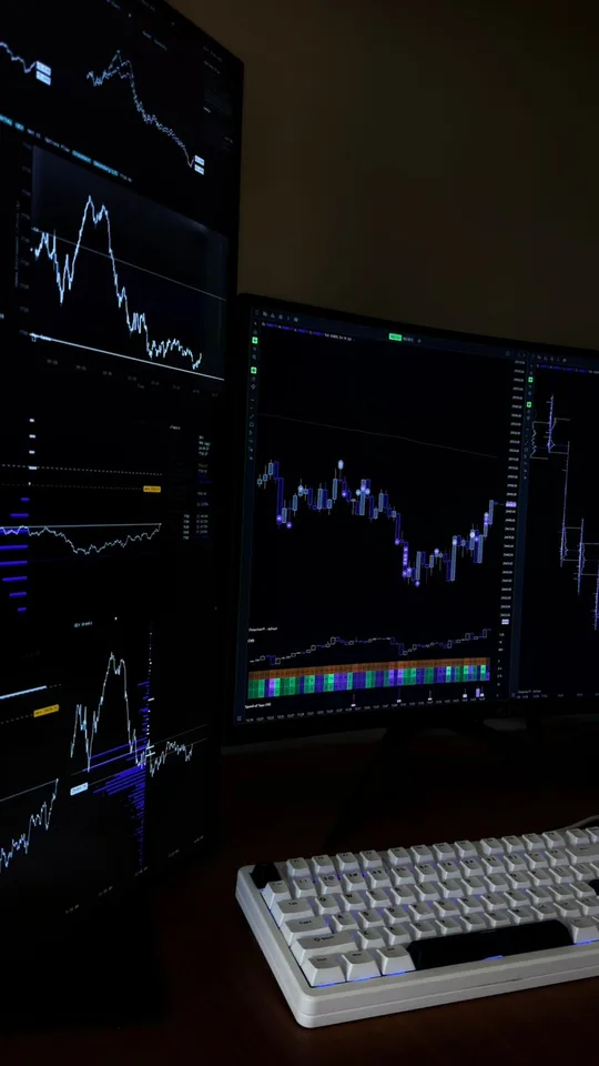 Vertical multi-monitor trading workstation displaying charts and market analytics